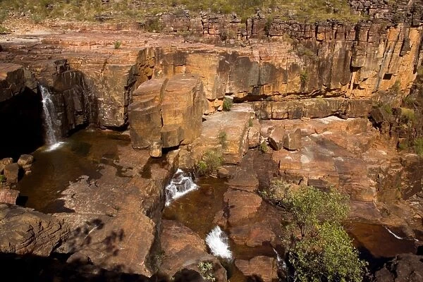 Twin Falls Plateau - water cascades over red rocks and cliffs on Twin Falls Plateau which is high up on top of Twin Falls - Kakadu National Park, Northern Territory, Australia