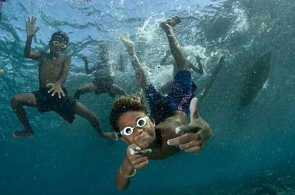 Underwater boys wearing goggles playing in the water