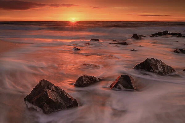 USA, New Jersey, Cape May National Seashore. Sunrise on rocky shore and ocean. Date: 28-12-2020