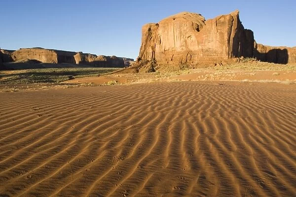 USA - Structural forms in the sand against the background of a sandstone mesa in the southern part of the Monument Valley. Monument Valley Navajo Tribal Park, Navajo Nation, Arizona / Utah, USA