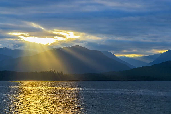 USA, Washington State, Seabeck. Sunburst over Hood Canal and Olympic Mountains at sunset. Date: 13-09-2021