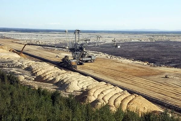 Vattenfall Europe Opencast brown coal (lignite) mine and simultaneous backfilling - near Weisswasser - Saxony NE Germany. (note the bulldozer in front of the big excavator for scale object)