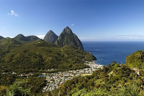 A view of The Pitons Mountains, with dense green undergrowth in the middle ground. St Lucia