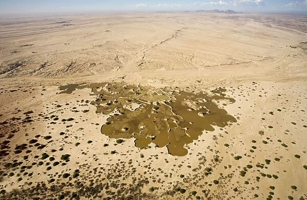 Water from recent rains accumulates in an excavation site where sand is dug up to supply the building trade - Namib Desert - Namibia - Africa