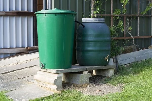 Water Tanks - two linked green plastic water butts collecting rainwater from shed roof. Cheltenham UK