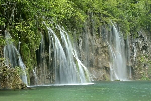 Waterfall cascades and emerald pool in forest at the upper lakes area Plitvice Lakes National Park, Croatia