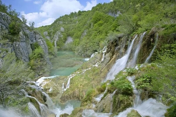 Waterfall cascading down steep cliffs in lower canyon forming the korana river Plitvice Lakes National Park, Croatia