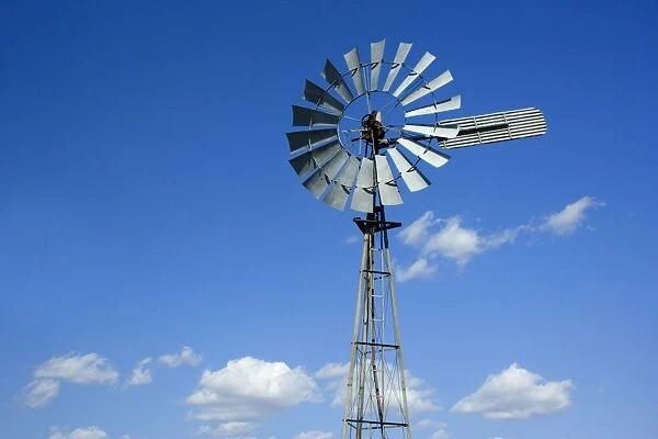 Wind wheel - typical wind wheel used in Australia's outback to pump water, and fluffy clouds - Outback Queensland, Australia
