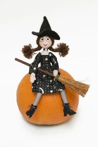 Witch - with broom sitting on a pumpkin