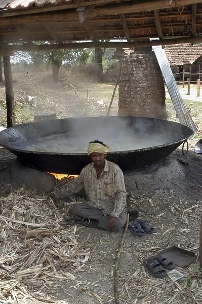 Worker - Sugar factory, India. Shows boiling pan in which sugar solution is evapourated to form syrup, using crushed cane as the fuel