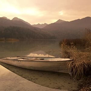 Boat at lake in the bavarian mountains in autumn Weissensee, Bavaria, Germany