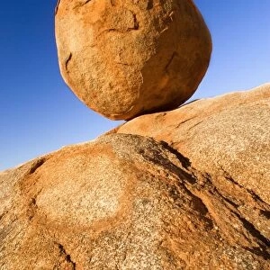 Devils Marbles - a nearly perfectly circular shaped boulder of red granite is balanced on bedrock. The Devils Marbles, also called Karlu Karlu in indigenous language