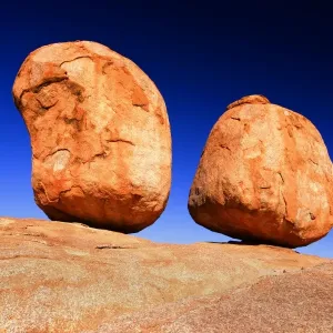 Devils Marbles - two nearly perfectly circular shaped boulder of red granite balanced on bedrock - Devils Marbles Conservation Area, Northern Territory, Australia Devils Marbles - two nearly perfectly circular shaped boulder of red granite balanced on bedrock - Devils Marbles Conservation Area, Northern Territory, Australia