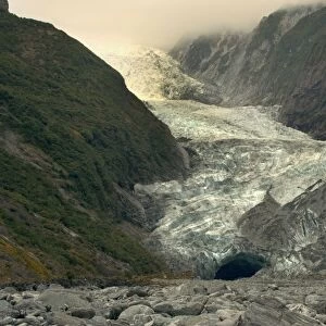 Franz Josef Glacier river of ice cutting through glacial valley nestled amidst mountains covered by primeval rainforest Westland National Park, West Coast, South Island, New Zealand