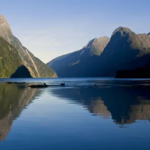 Milford Sound landmark Mitre Peak and surrounding mountains reflected in the calm waters of Milford Sound in early morning. Milford Sound is one of the, if not THE, most famous attraction in New Zealand