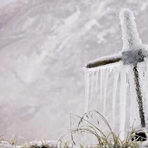 Old roadside cross covered with frost and icicles, high in the Fagaras Mountains, southern carpathians, Romania