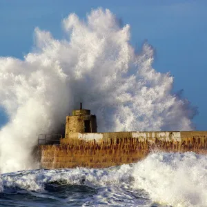 Portreath - wave breaks over pier in storm - Cornwall - UK