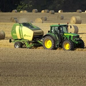Tractor making bales of hay in freshly cut wheat field - September - Staffordshire - England
