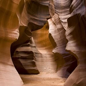 USA - Light that penetrates into the narrow canyon walls creates beautiful hues on the graceful curves of sandstone rock in the Upper Antelope Canyon, probably the most famous "slot canyon" in the Southwest. Antelope Canyon