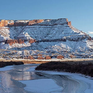 USA, Utah. Fisher Towers, La Sal Mountains, and canyon walls reflected in the icy Colorado River. Date: 05-01-2021