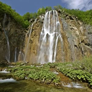Waterfall cascading down steep cliffs in lower canyon area Plitvice Lakes National Park, Croatia