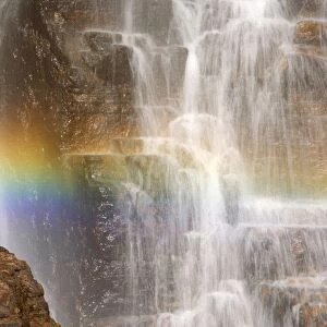 waterfall and rainbow - water cascading down a cliff with a rainbow forming in the water's spray. In the dry season this waterfall will soon be reduced to only a small trickle - Northern Territory, Australia