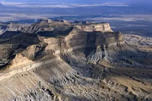 Aerial view of the Book Cliffs - north of the town of Green River, Utah; looking south towards Green River. The cliffs are carved into the Mancos Shale (marine deposits, grey talus slope), capped by sandstone of the Mesaverde Group