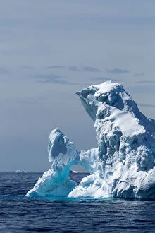 Antarctica, Sunshine lights arched iceberg