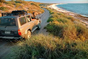 AUS-1869 Western Australia - well-equipped 4WD vehicle driving over rough track towards the beach