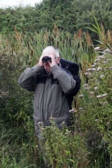 Birdwatchers Gallery: Birdwatcher - with binoculars in 'Parc ornithologique Birdwatcher - with binoculars in 'Parc