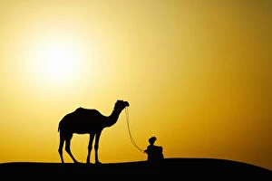 Images Dated 8th August 2012: Camel and camel driver silhouetted at sunset