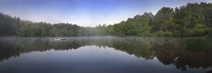 Canoist on small lake at sunrise, Delaware