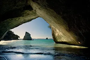 New Zealand Prints: Cathedral Cove by erosion artfully sculpted rock formation seen from the inside of a natural rock arch at Cathedral