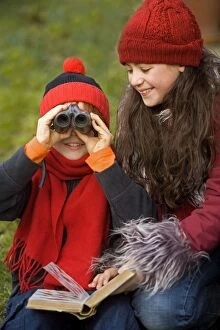 Children - boy and girl birdwatching with binoculars