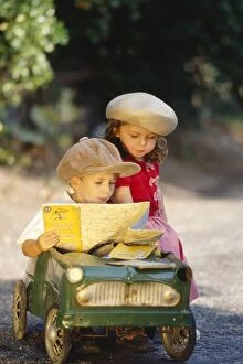 Boys Gallery: CHILDREN - cute boy and girl in toy car, reading map