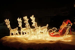 House Collection: Christmas Decorations - illuminated reindeer & sleigh outside house. France