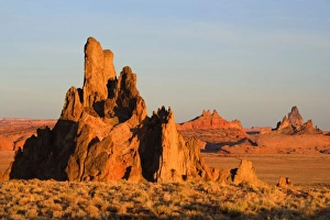 Church Rock - sandstone formation called Church Rock, Comb Ridge in the middle and Agathla Peak in the background in late evening light Church Rock - sandstone formation called Church Rock, Comb Ridge in the middle and Agathla Peak in the background in late evening light