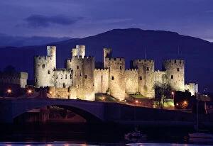 Tourism Collection: Conwy Castle - being lit up at dusk - November - North Wales - UK