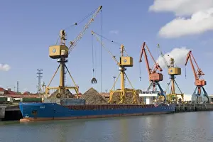 Moored Prints: Cranes on quayside unloading scrap metal from cargo shipsinto trucks for reprocessing Bilbao docks Spain