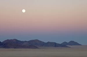 Dawn with full moon at the edge of the Namib Desert