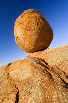Devils Marbles - a nearly perfectly circular shaped boulder of red granite is balanced on bedrock. The Devils Marbles, also called Karlu Karlu in indigenous language
