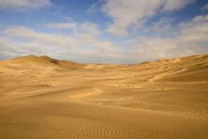 Dune scene - under a blue sky with light clouds