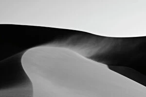 Dunes in late afternoon light - with sand blowing over the crest in a smoke stack - Dune Fields