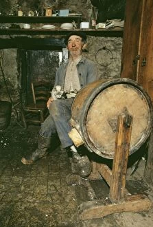 Barns Gallery: Elderly French Man - sitting with cat making butter