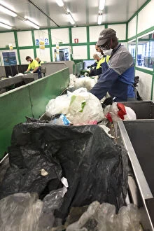 Environmental Issue Gallery: Employees of a waste facility on a conveyor belt