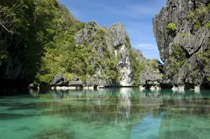 The exit (between the rocks) of a Big Lagoon of El Nido Minilok island, corals are visible in clear waters. Near El Nido Minilok resort, El Nido, Palawan, Philippines. February. Ph41. 0928