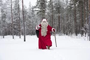 Father Christmas / Santa waking through snow landscape w