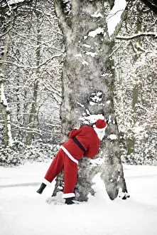 Christmas Prints: Father Christmas - in snow - behind tree