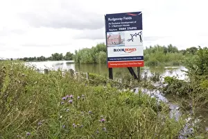 Flooding - Large bill board adverting exclusive development of new houses on inundated flood plain Newtown Tewkesbury Gloucestershire UK following unprecedented flooding of Rivers Severn and Avon July 2007