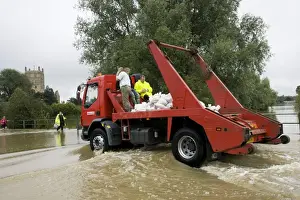 Lorries Prints: Flooding - Lorry carrying sand bags driving along flooded road opposite Tewkesbury Abbey Gloucestershire UK Level of